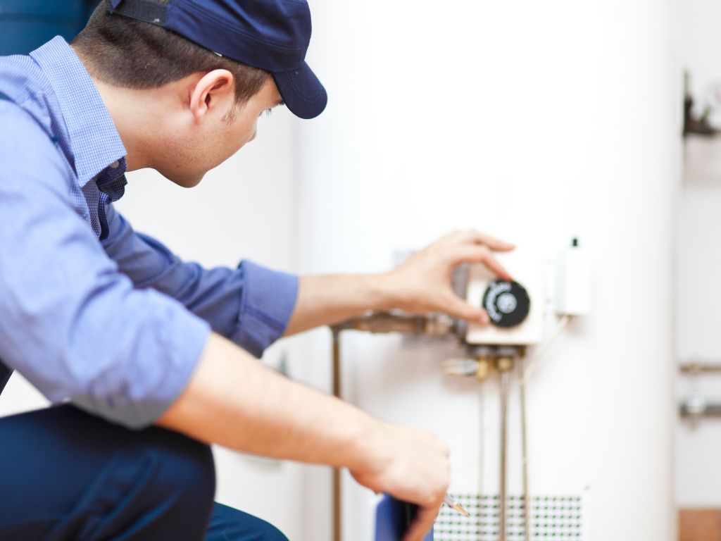 11 Common Types Of Plumbing Emergencies And How To Handle Them 5 Technician inspecting water heater